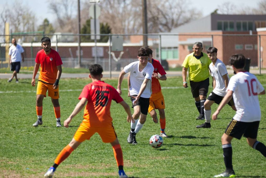 Grupo de hombres jugando al fútbol durante el día.
